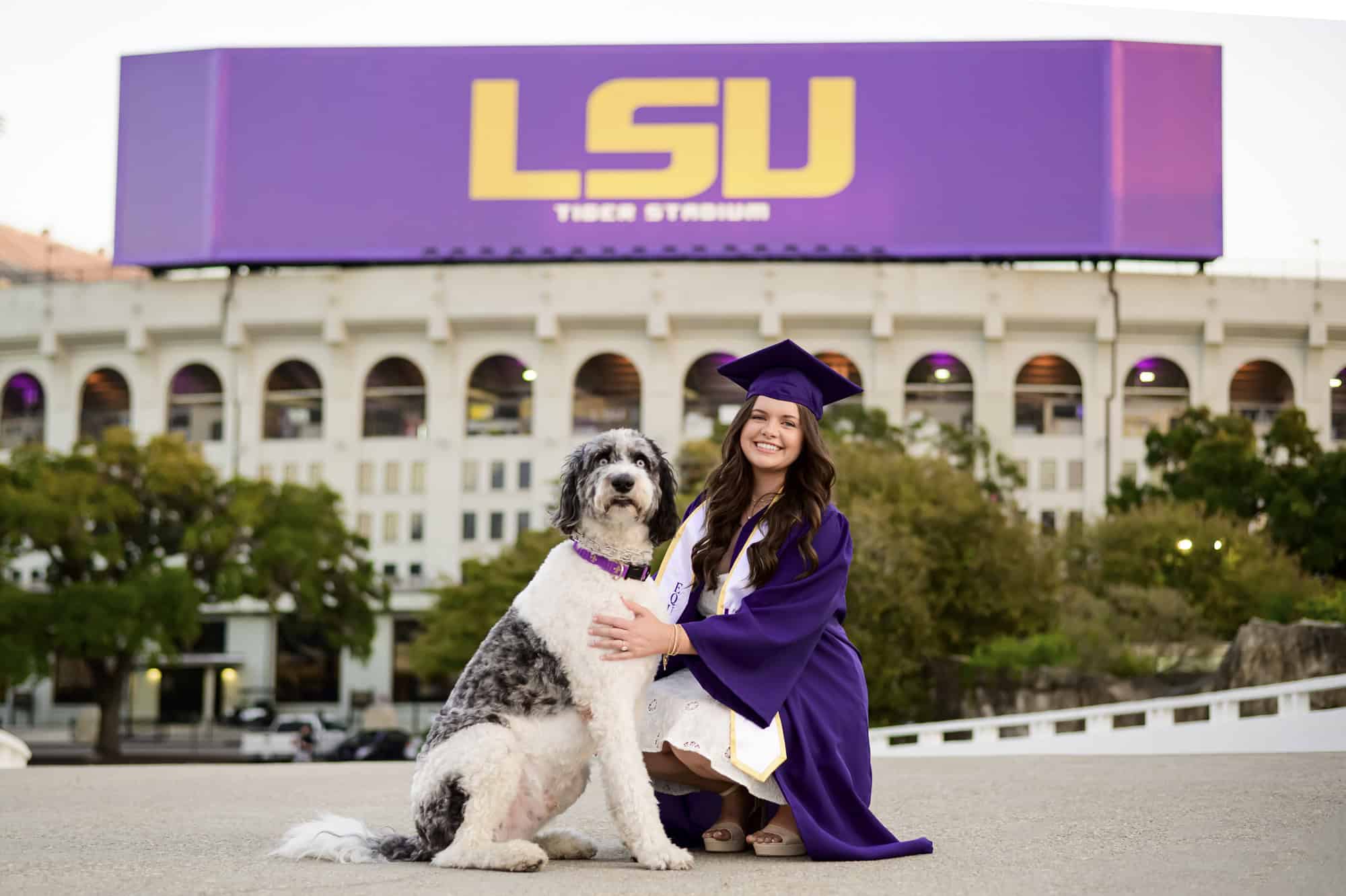 LSU senior posing with her dog during senior portraits on LSU campus in Baton Rouge, Louisiana
