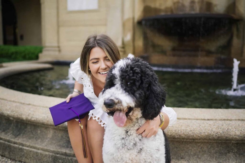 LSU senior posing with her dog during senior portraits on LSU campus in Baton Rouge, Louisiana
