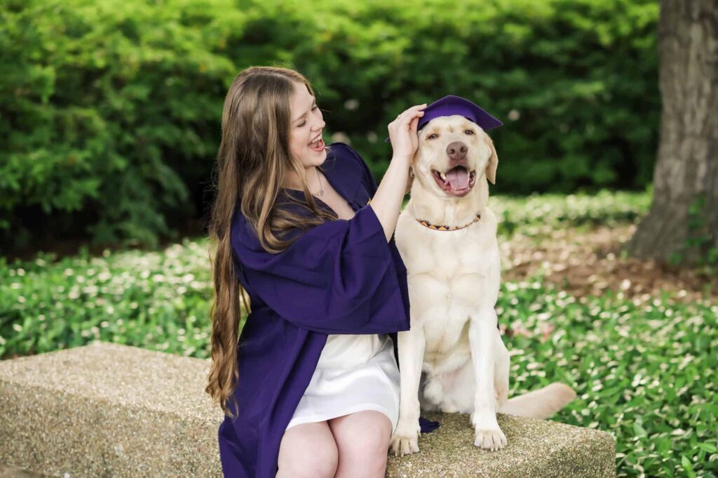 LSU senior posing with her dog during senior portraits on LSU campus in Baton Rouge, Louisiana
