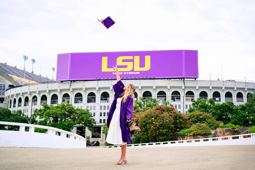 LSU senior tosses her cap at the PMAC during graduation portraits on LSU campus in Baton Rouge, Louisiana