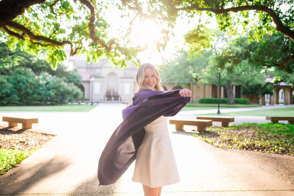 LSU senior tosses her gown at in the quad during graduation portraits on LSU campus in Baton Rouge, Louisiana