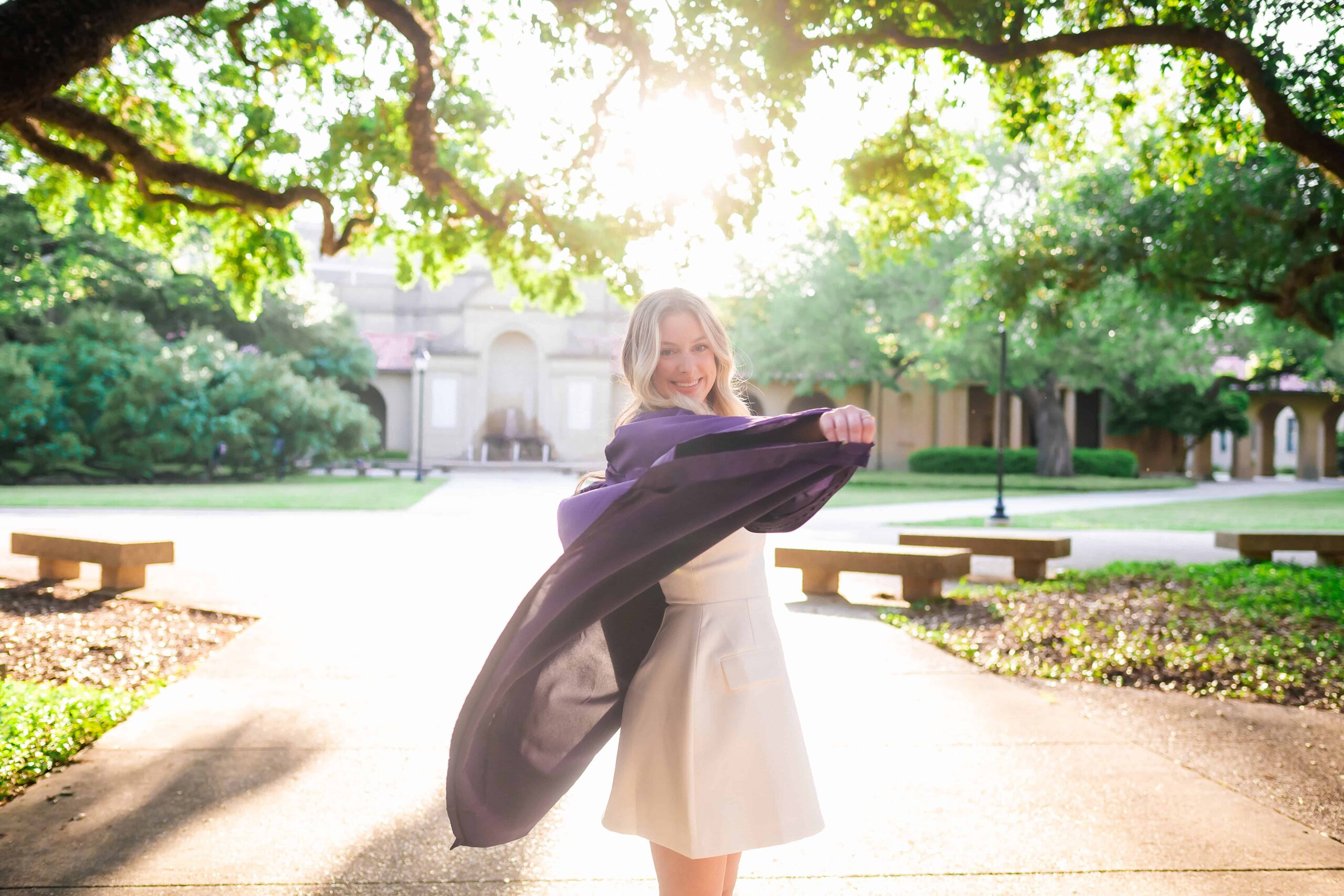 LSU senior tosses her gown at in the quad during graduation portraits on LSU campus in Baton Rouge, Louisiana
